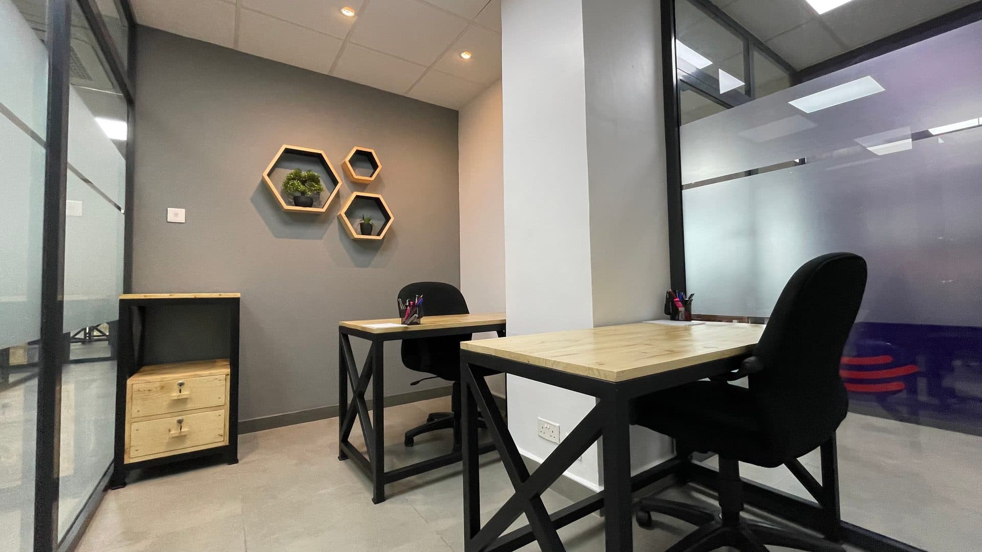 A two-person office at The Hive seen through the glass door